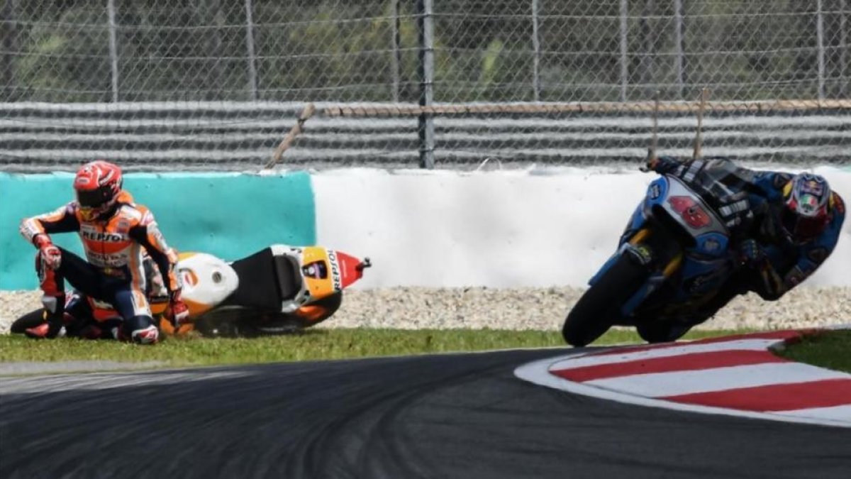 Marc Márquez (Honda) se ha caído hoy en la última curva de Sepang, justo delante del australiano Jac Miller (Honda).-AFP / MOHD RASFAN
