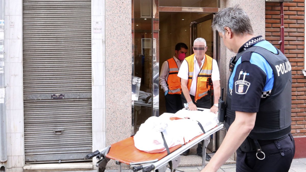 Los servicios funerarios retiran el cadáver de una de las dos mujeres de la calle Linares 32. / ICAL