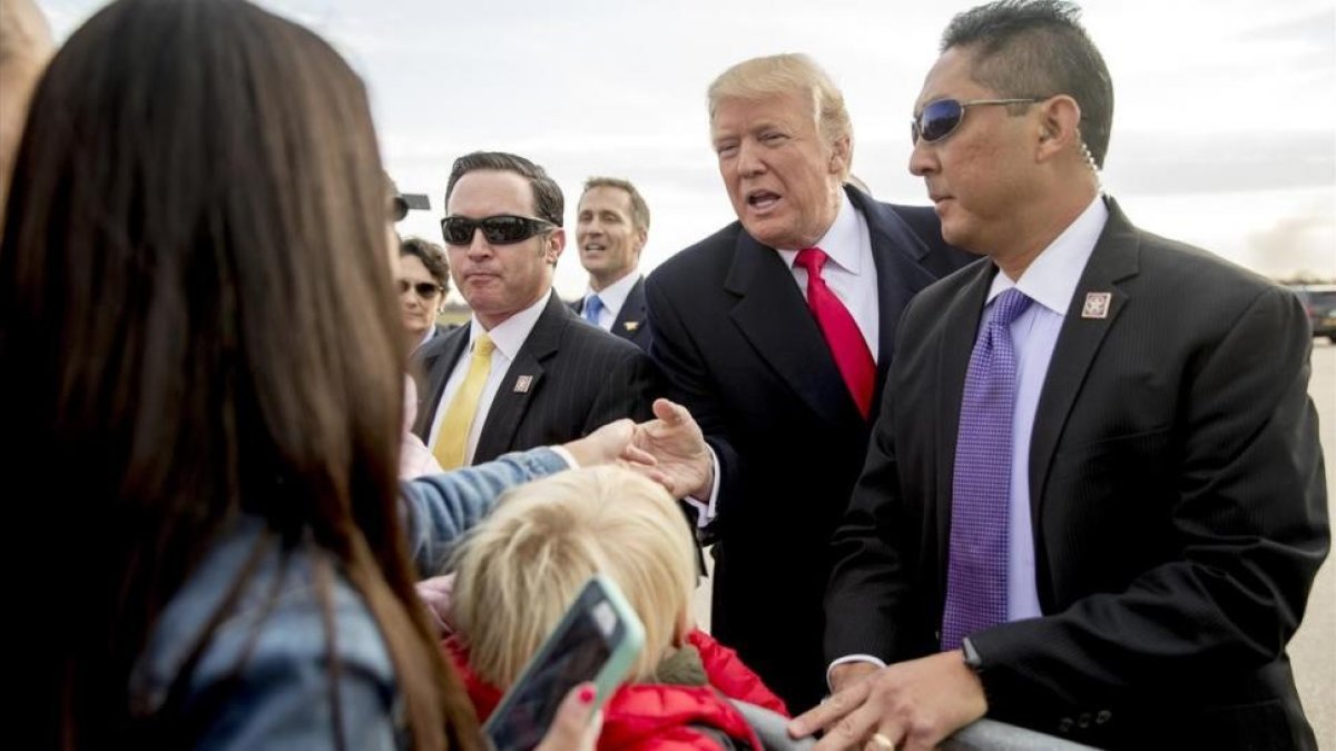 Trump (centro) saluda a varios ciudadanos a su llegada al aeropuerto internacional de Saint Louis, el 29 de noviembre.-AP / ANDREW HARNIK