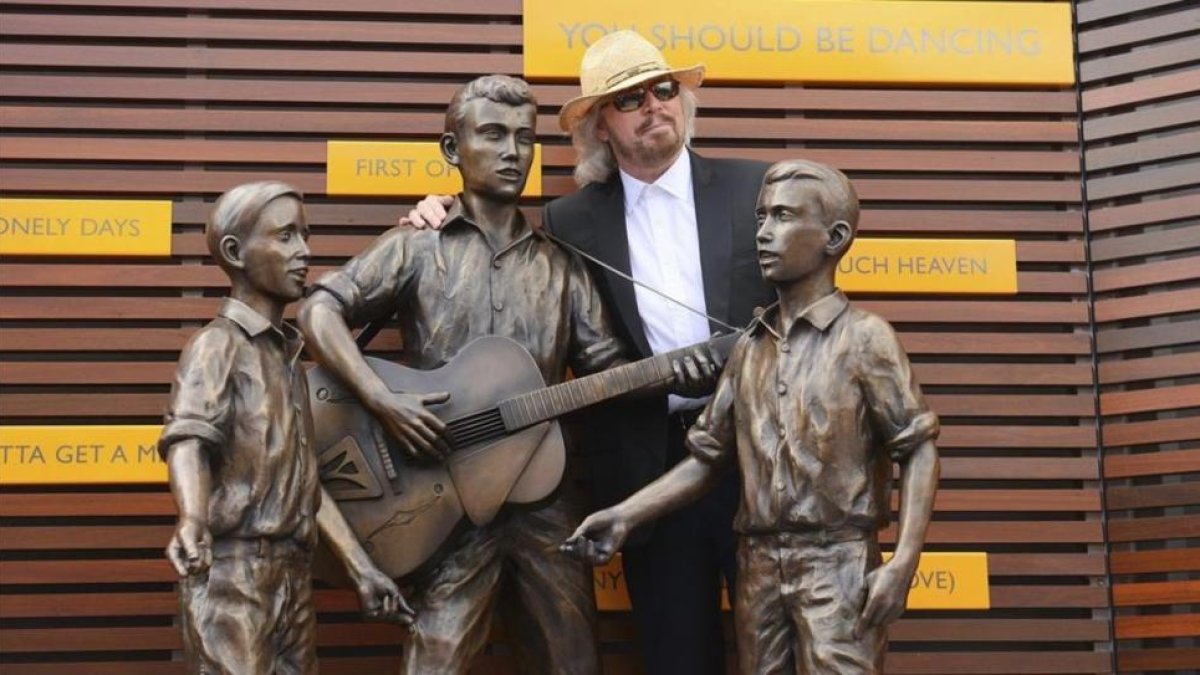 Barry Gibb posa junto a una estatua en honor de Barry  Robin y Maurice Gibbs  componentes del grupo Bee Gees en la inauguracion oficial del Paseo de lo Bee Gees en en Redcliffe, norte de Brisbane (Australia), en febrero del 2013.-