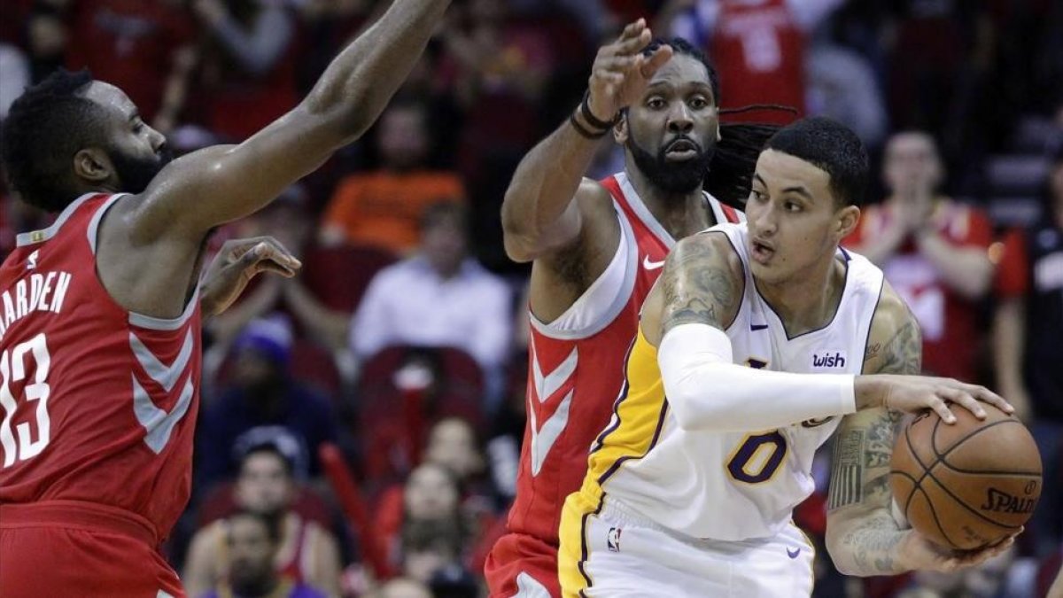 Kyle Kuzma intenta pasar el balón bajo la presión de James Harden y Nene Hilario-MICHAEL WYKE