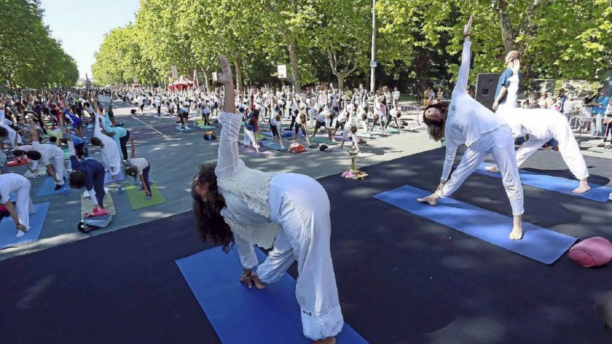 Cientos de personas en la Acera de Recoletos hacen yoga.-Ical