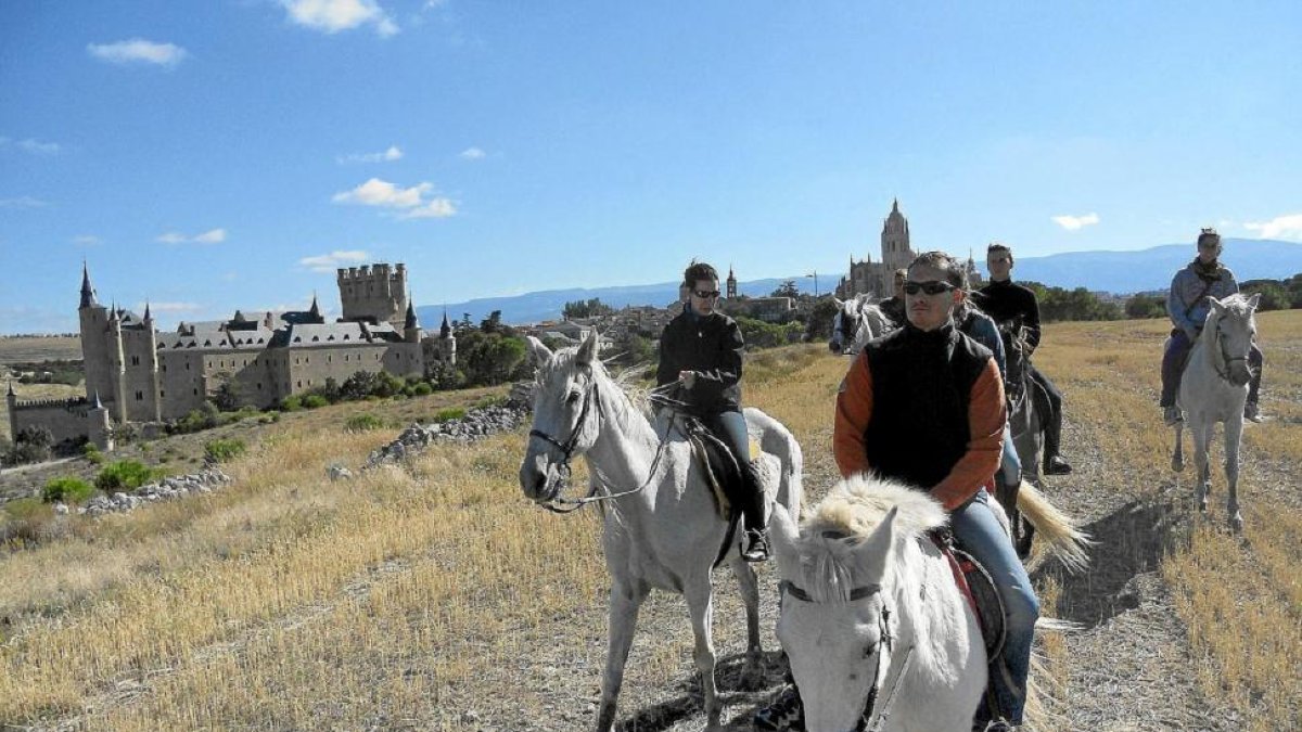 Un grupo de turistas a caballo en las inmediaciones de Segovia, en una imagen de archivo.-ICAL