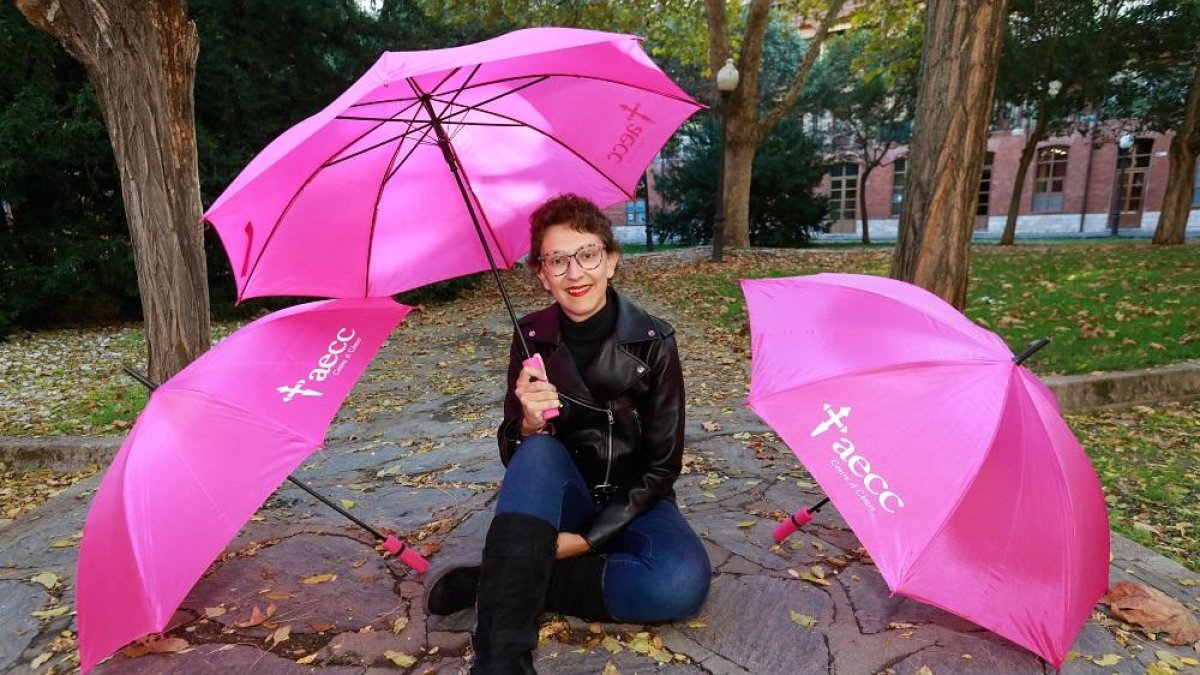 Verónica Alija posa con tres paraguas de la AECC tras superar el cáncer de mama.-J. M. LOSTAU