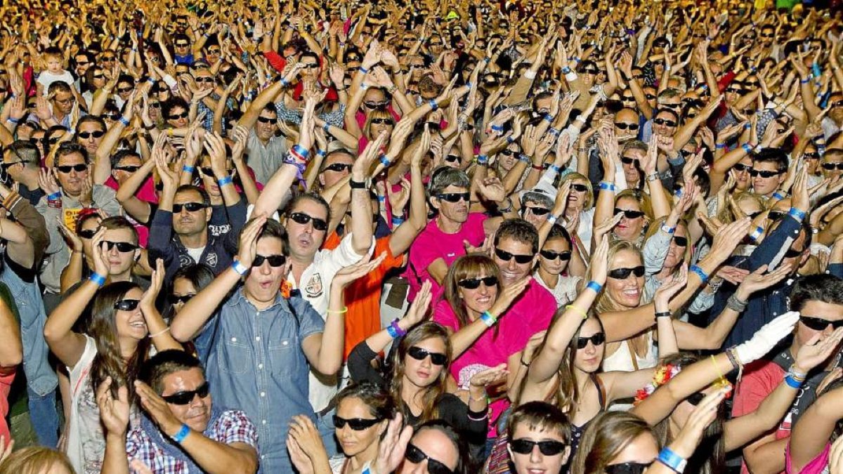 Miles de personas bailan al ritmo de la música durante el ataque al récord Guiness del máximo número de personas con gafas de sol ayer a primera hora de la noche en la Acera de Recoletos.-J. M. Lostau