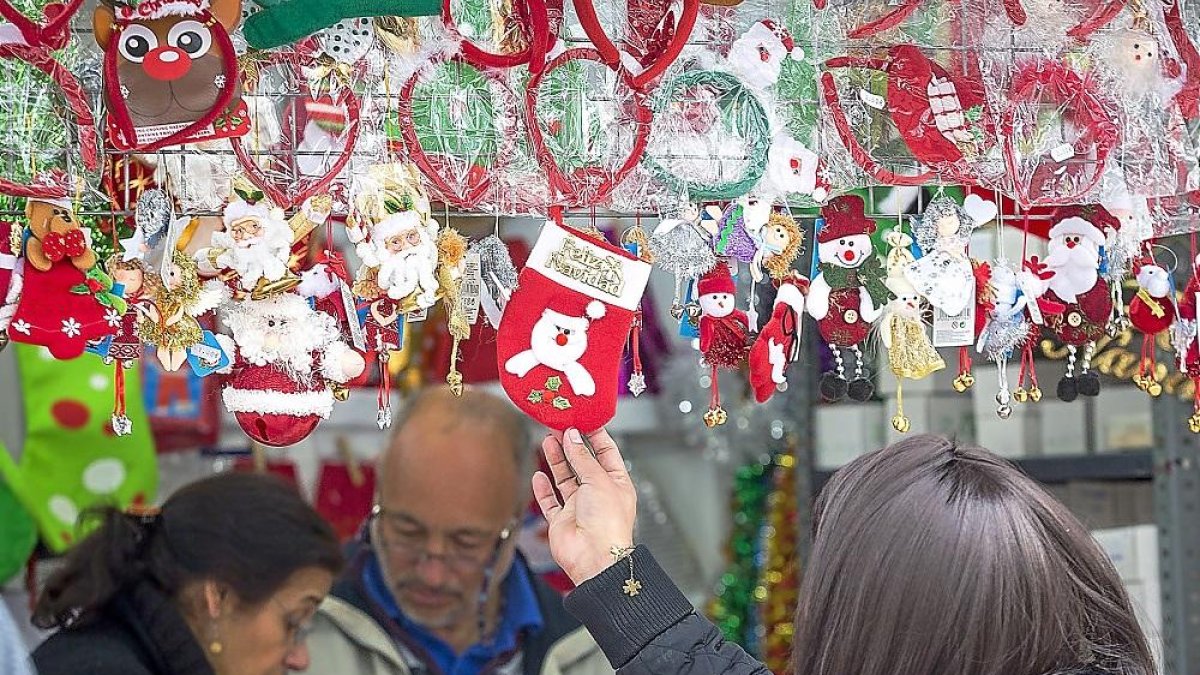 Una mujer contempla los productos de una de las casetas navideñas de la acera de Recoletos.-M. Á. SANTOS (PHOTOGENIC)