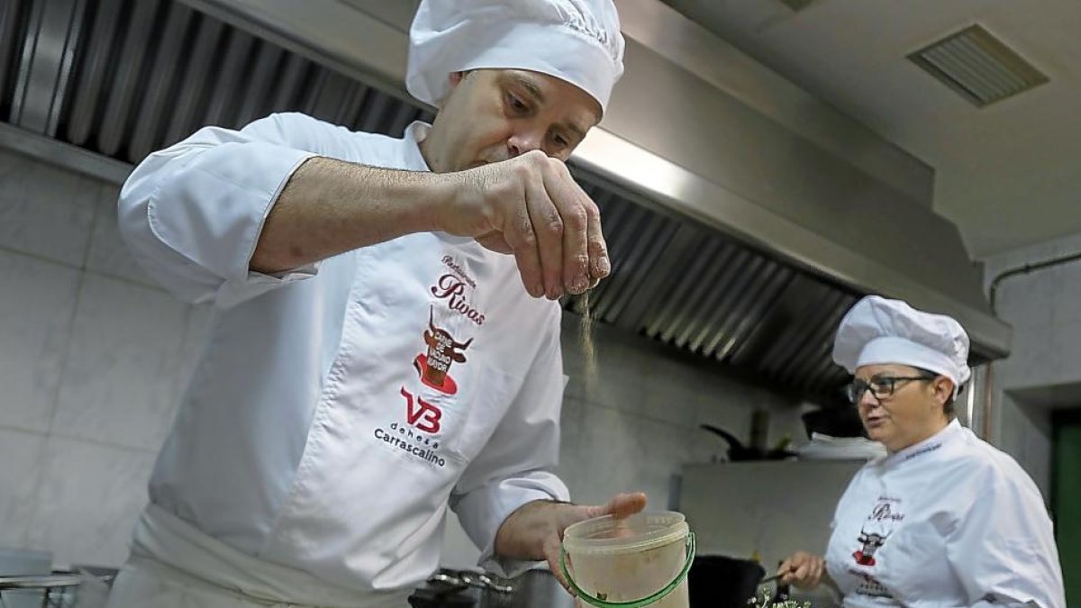 Óscar Barreno y la jefa de cocina Ana Rosa Cuadrado mientras trabajan en la cocina del Rivas (Salamanca).-ENRIQUE CARRASCAL