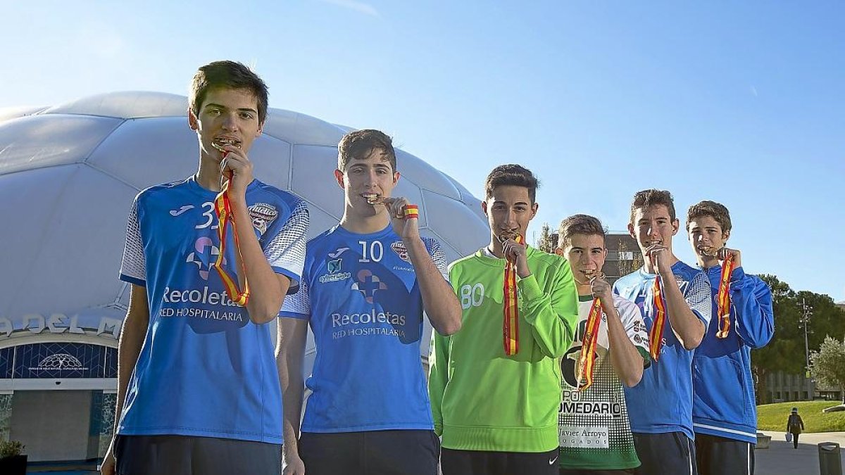 Pablo Herrero, DiegoPérez, Daniel Tsevelinov, SergioCasares, Alejandro Pisonero y Matías Bergara muerden sus medallas de campeones de España.-NURIA MONGIL