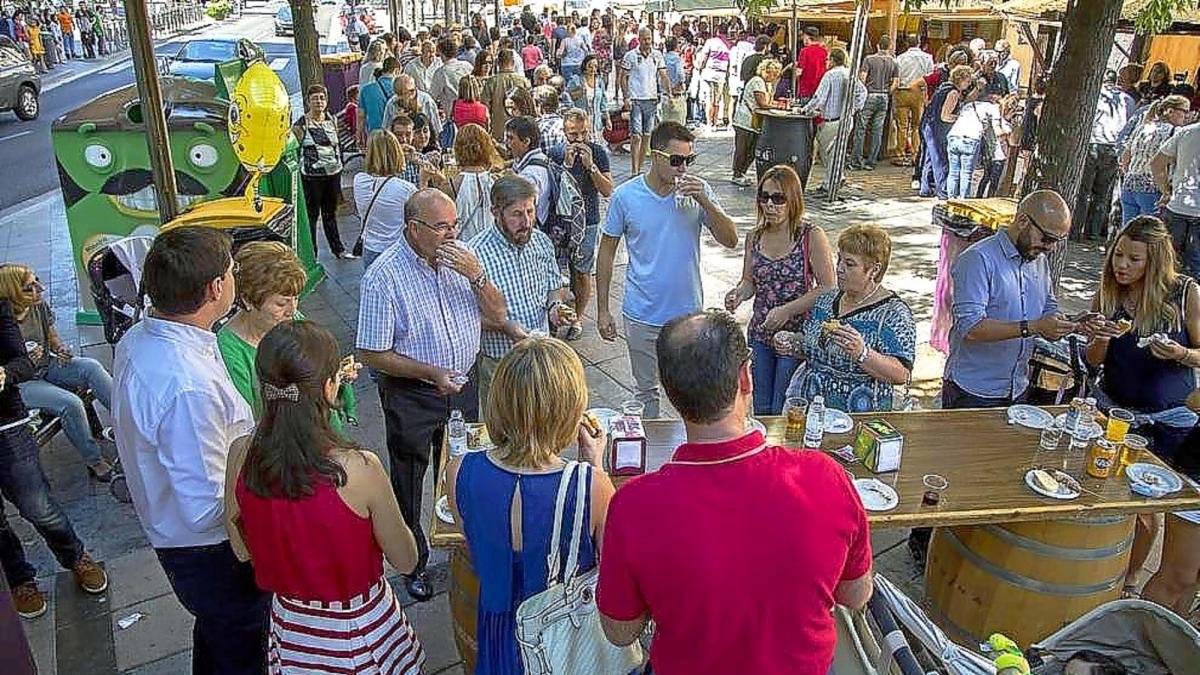 Personas disfrutando de la comida y la bebida en una de las casetas.-E.M.