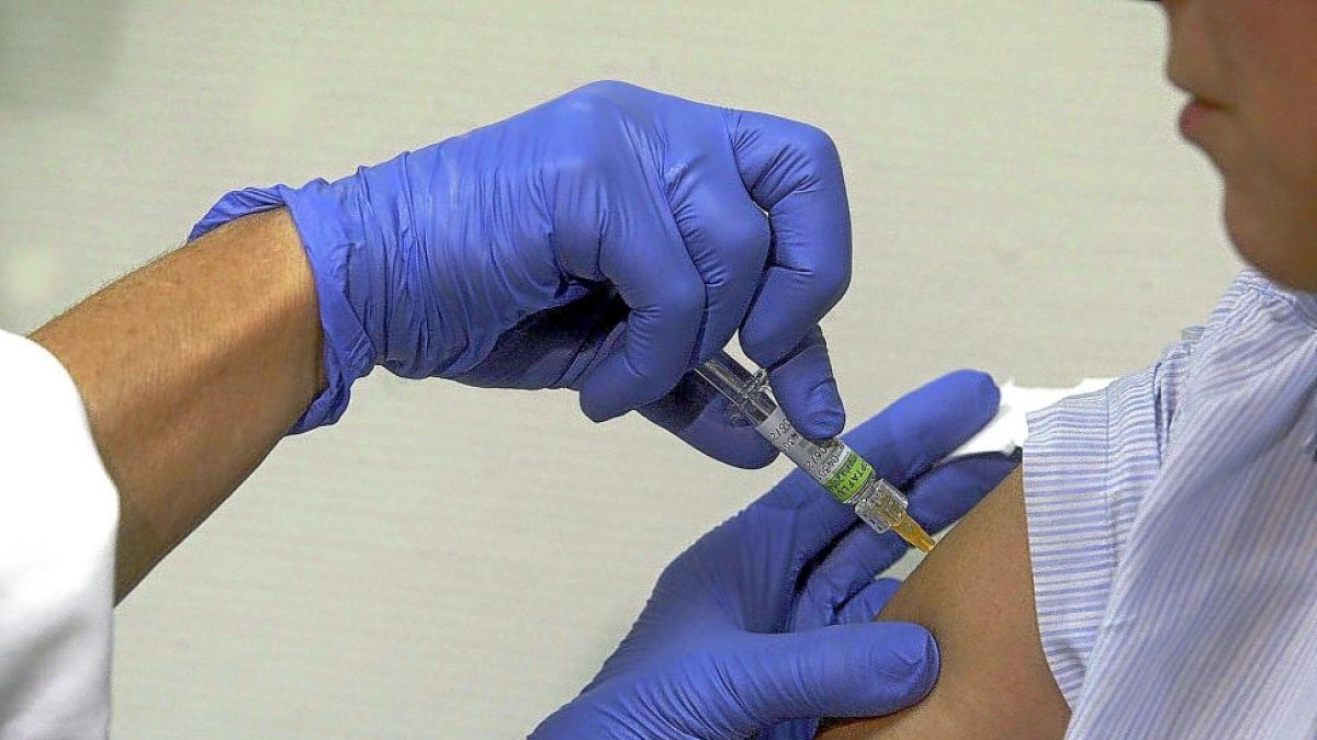 Un enfermero administra la vacuna de la gripe a un ciudadano durante la pasada campaña.-ICAL