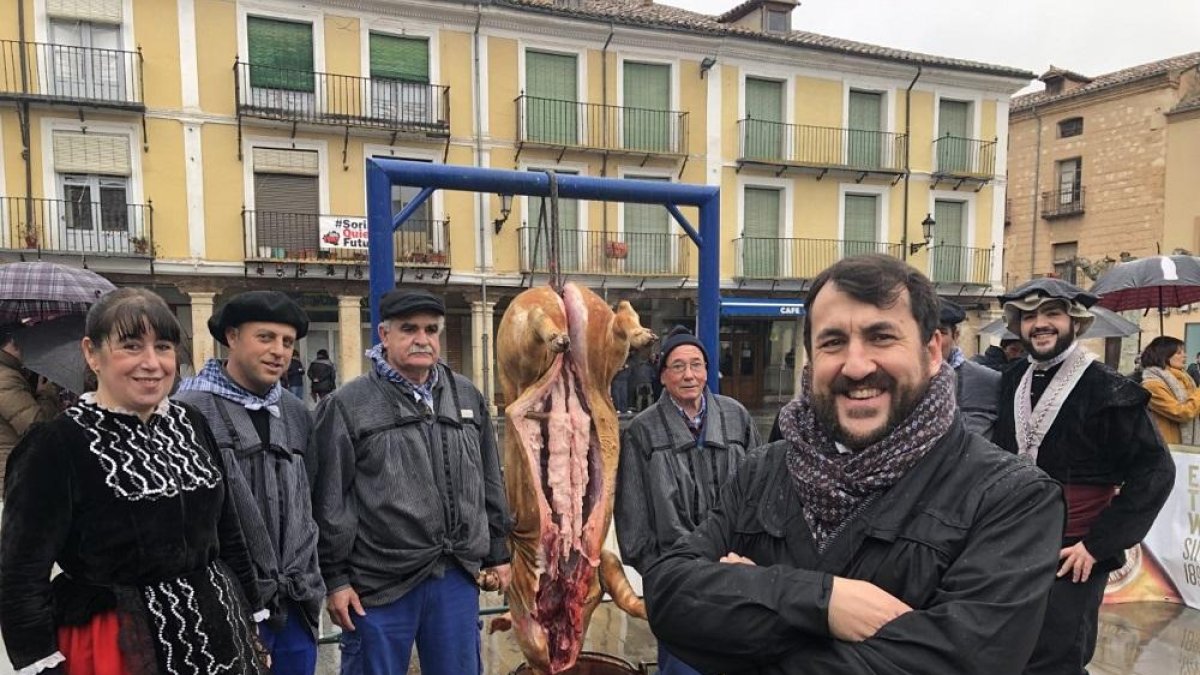 Armando García González, en primer plano con los brazos cruzados, ante el rito de la matanza representado en la Plaza Mayor de El Burgo de Osma.-E.M.
