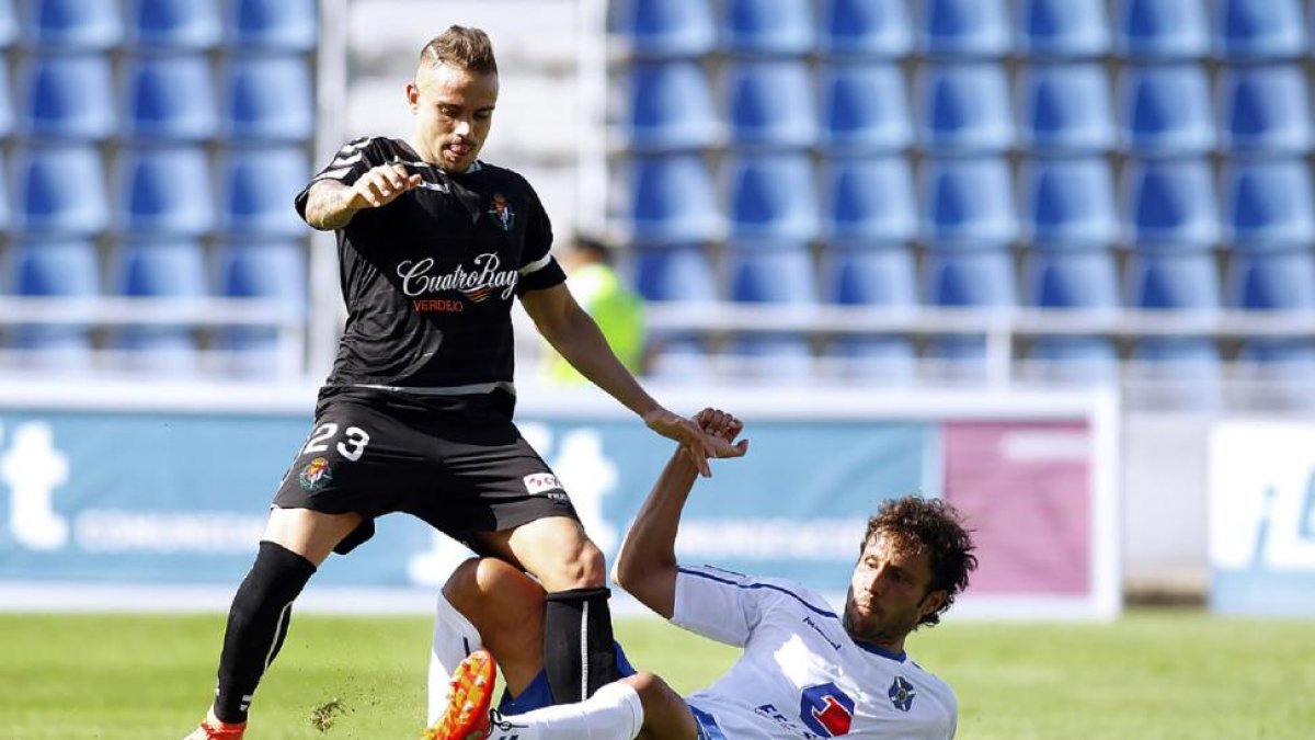Roger intenta llevarse el balón en pugna con Germán en el partido disputado ayer en el Heliodoro Rodríguez.-PHOTO-DEPORTE