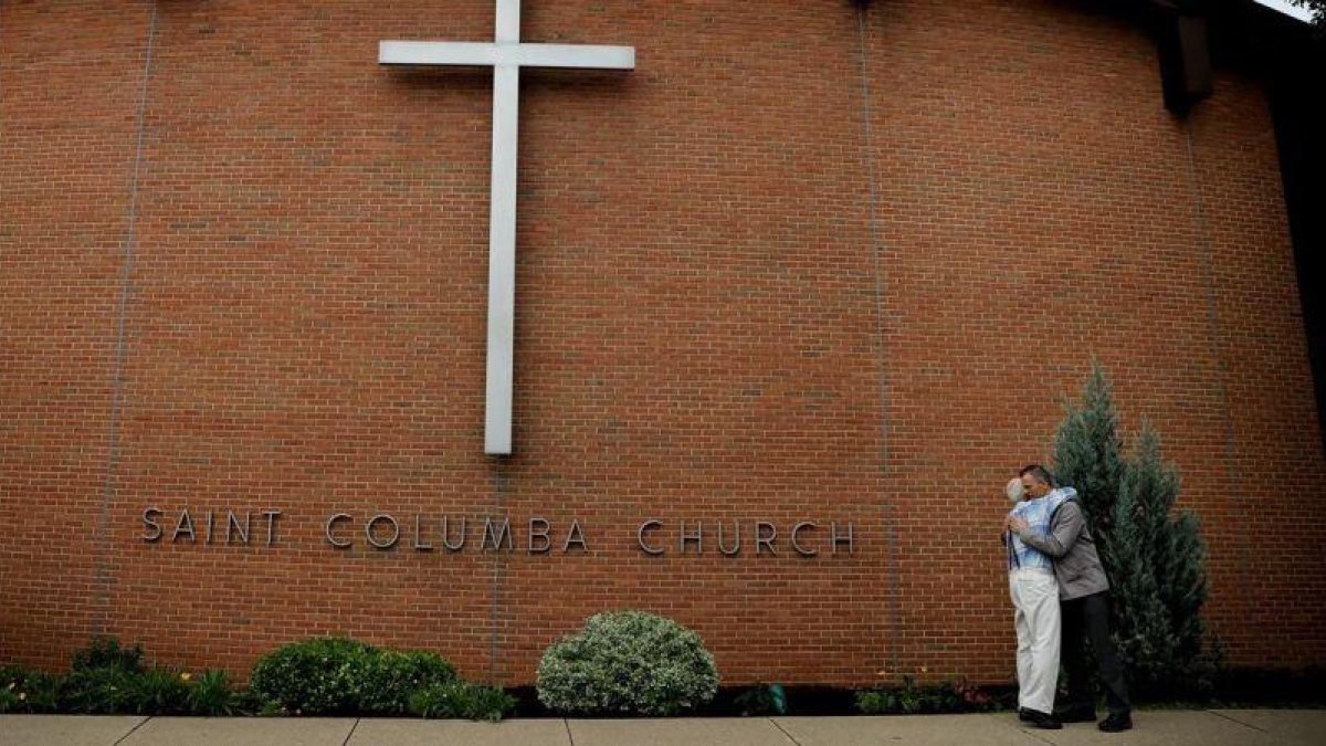 Dos miembros de la Iglesia de Santa Columba, en Bloomsburg (Pensilvania), se abrazan.-CARLOS BARRIA (REUTERS)