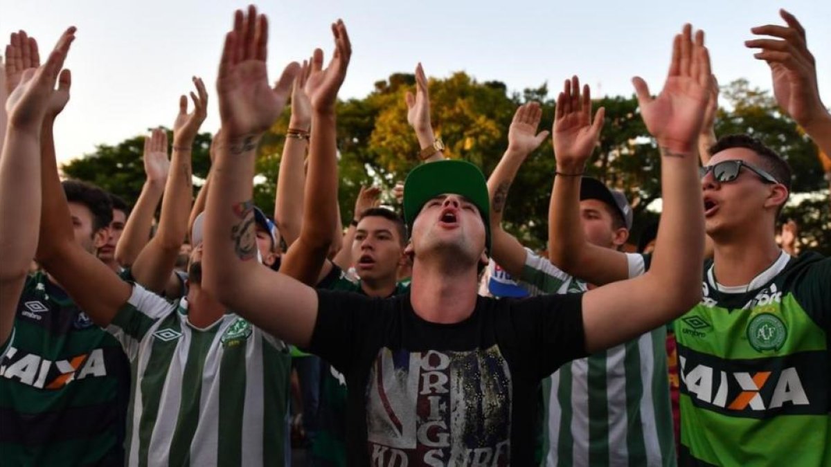 Seguidores del Chapecoense rinden homaneja a los fallecidos.-AFP / NELSON ALMEIDA