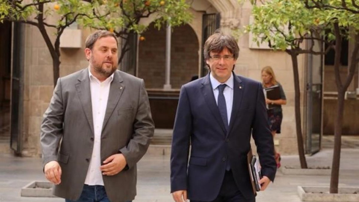 El 'president' Puigdemont y el vicepresidente Junqueras llegando a la reunión del Govern este martes.-RICARD CUGAT