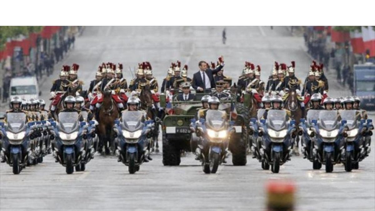 Macron saluda desde un vehículo militar a su paso por los Campos Elíseos.-MICHEL EULER