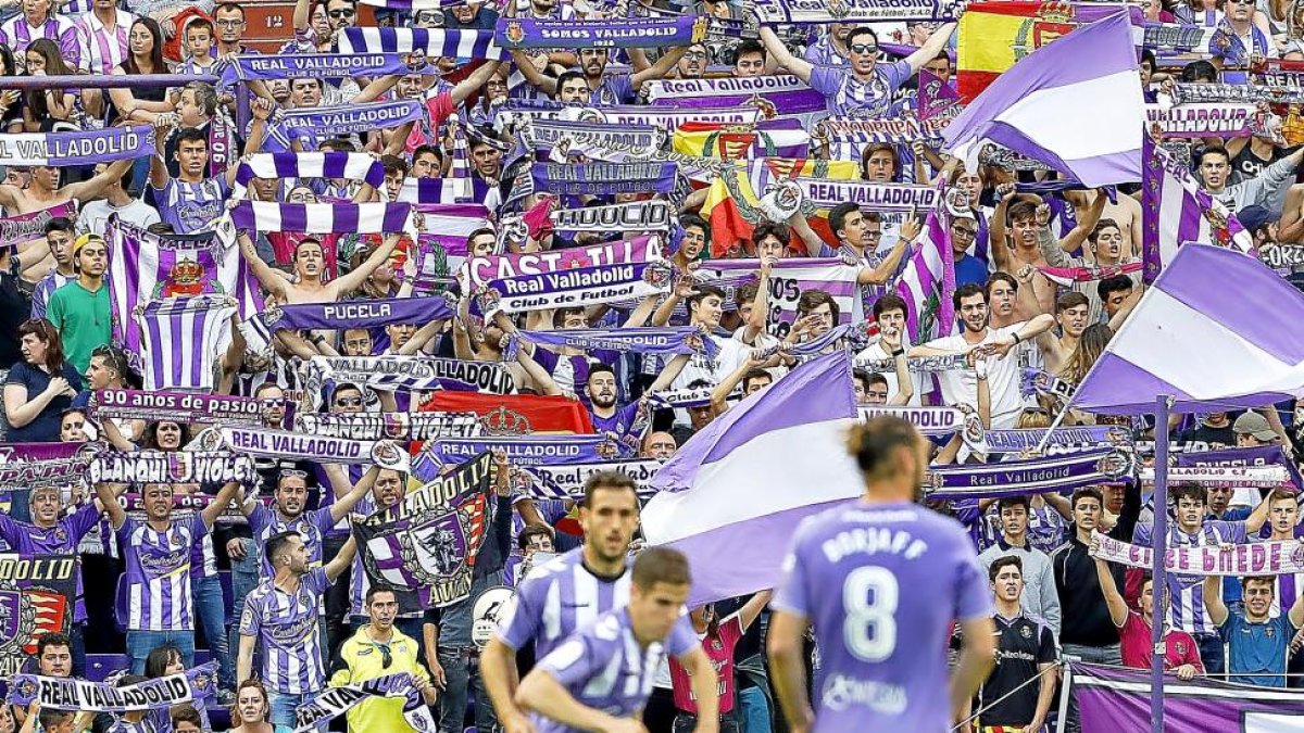Kiko Olivas, Hervías y Borja, ayer durante el partido con la afición mostrando banderas y bufandas al fondo de la imagen.-J.M. LOSTAU