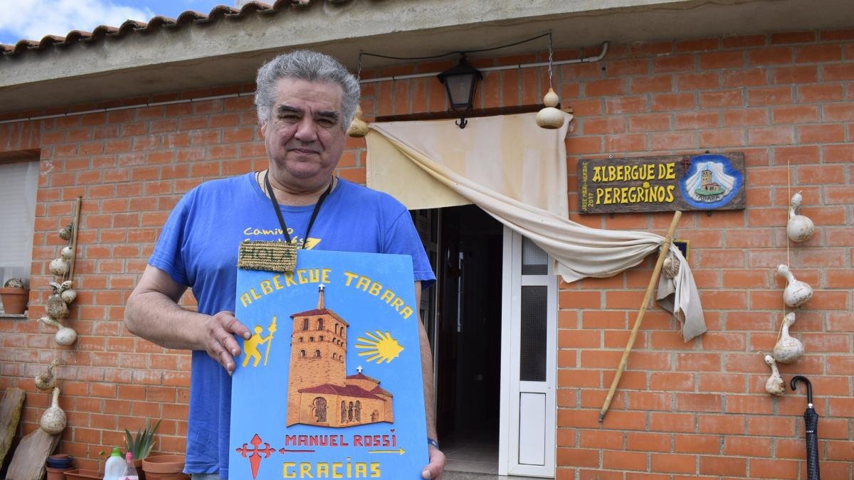 El hospitalero zamorano José Almeida, en el albergue de peregrinos de Tábara, que gestiona desde hace cuatro años, con una placa de agradecimiento enviada por un peregrino, después de pernoctar allí en su ruta hacia Santiago.-ARGICOMUNICACIÓN
