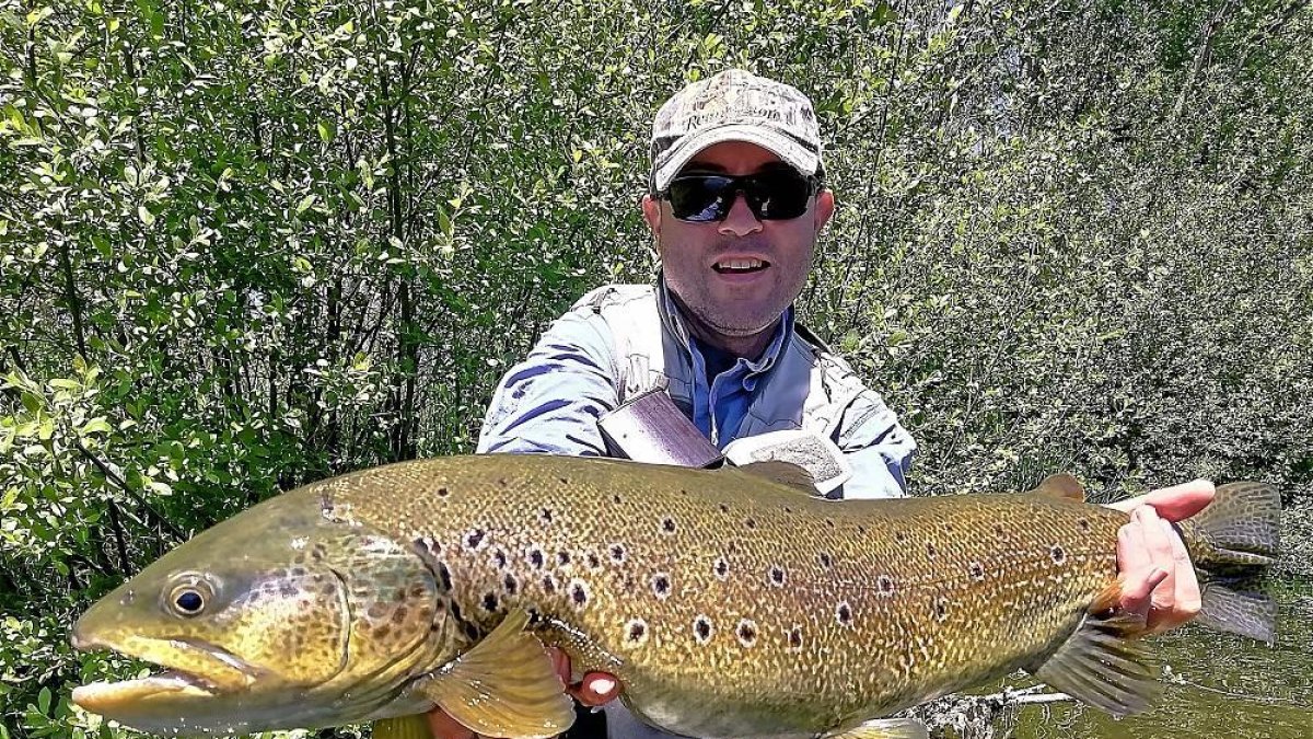 Diego Corral García, el pasado lunes, con su descomunal trucha común capturada a ninfa en un coto salmantino del río Tormes.-EL MUNDO