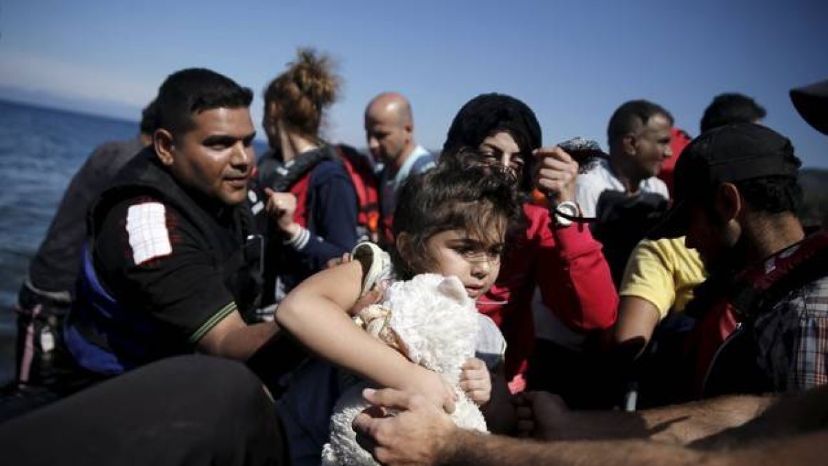 Una niña siria es ayudada a bajar de su embarcación en la isla griega de Lesbos, este sábado.-Foto: REUTERS / ALKIS KONSTANTINIDIS