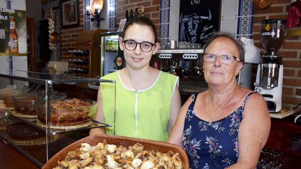 Cristina y su madre, Rosa María, con sus célebres torreznos y ajos fritos que se sirven en cazuela de barro de Portillo.-ARGICOMUNICACIÓN