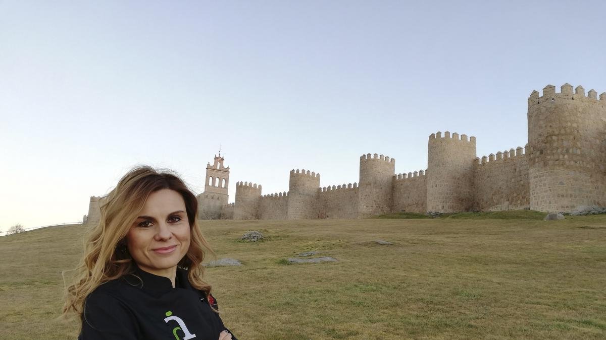 Gemma Rodríguez, ataviada con un delantal de Ávila Auténtica, delante de la imponente muralla romana abulense.-