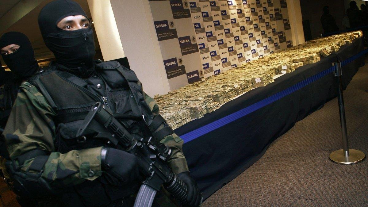Policía junto a los dolares decomisados-