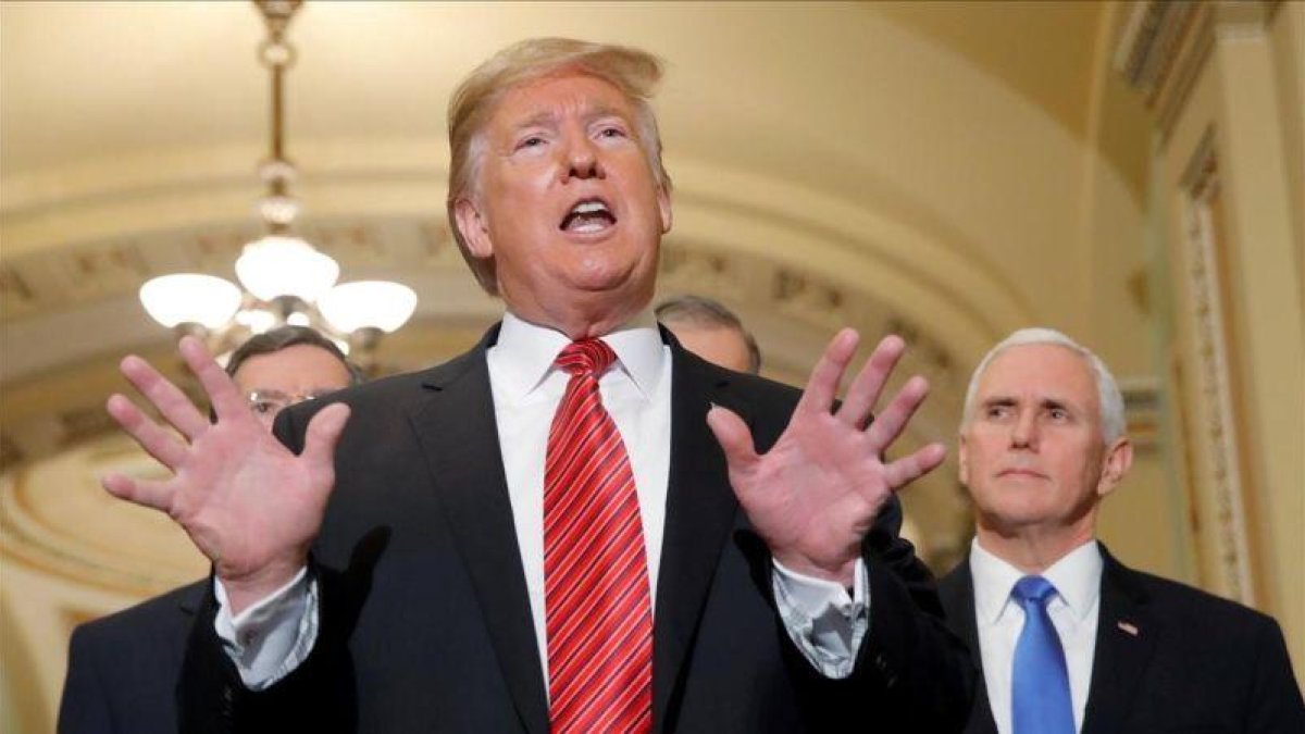 Donald Trump se dirige a la prensa junto al vicepresidente Mike Pence.-JIM YOUNG (REUTERS)