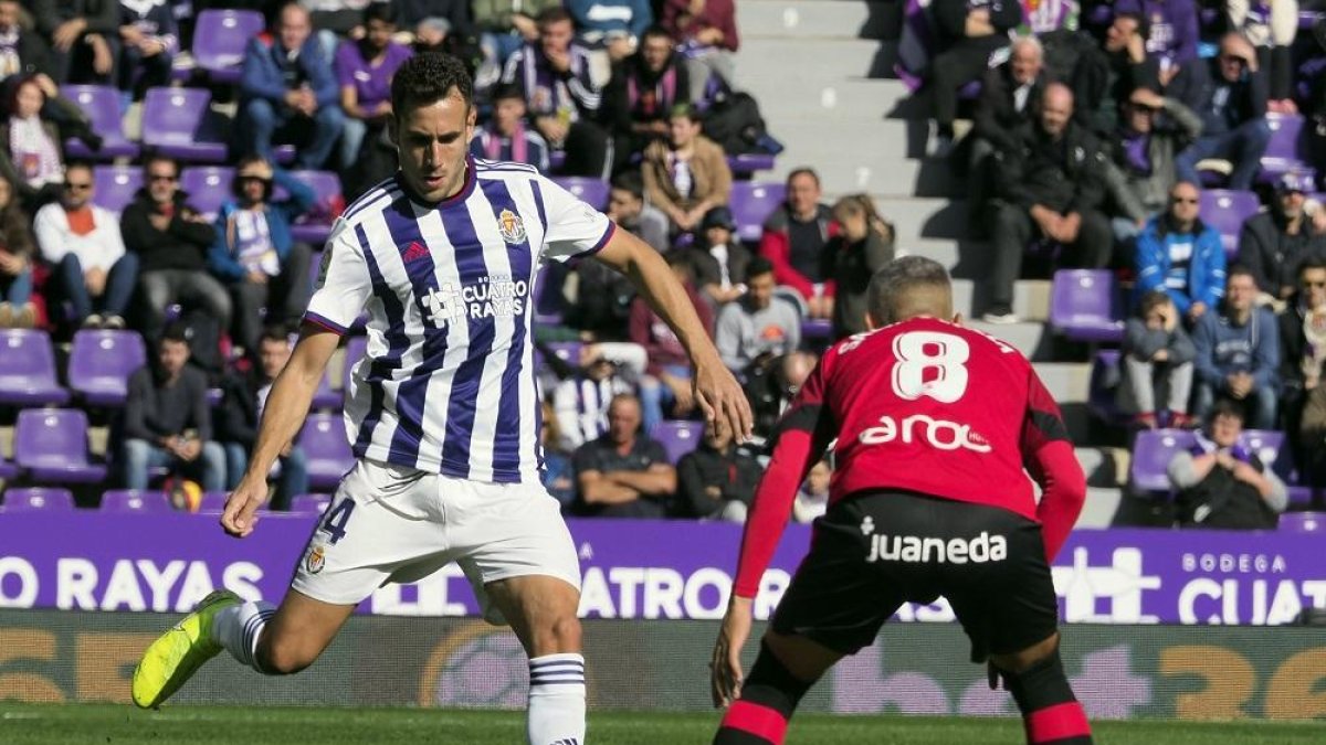 Kiko Olivas se dispone a despejar ante el mallorquinista Salva Sevilla, en la última victoria blanquivioleta.-PABLO REQUEJO