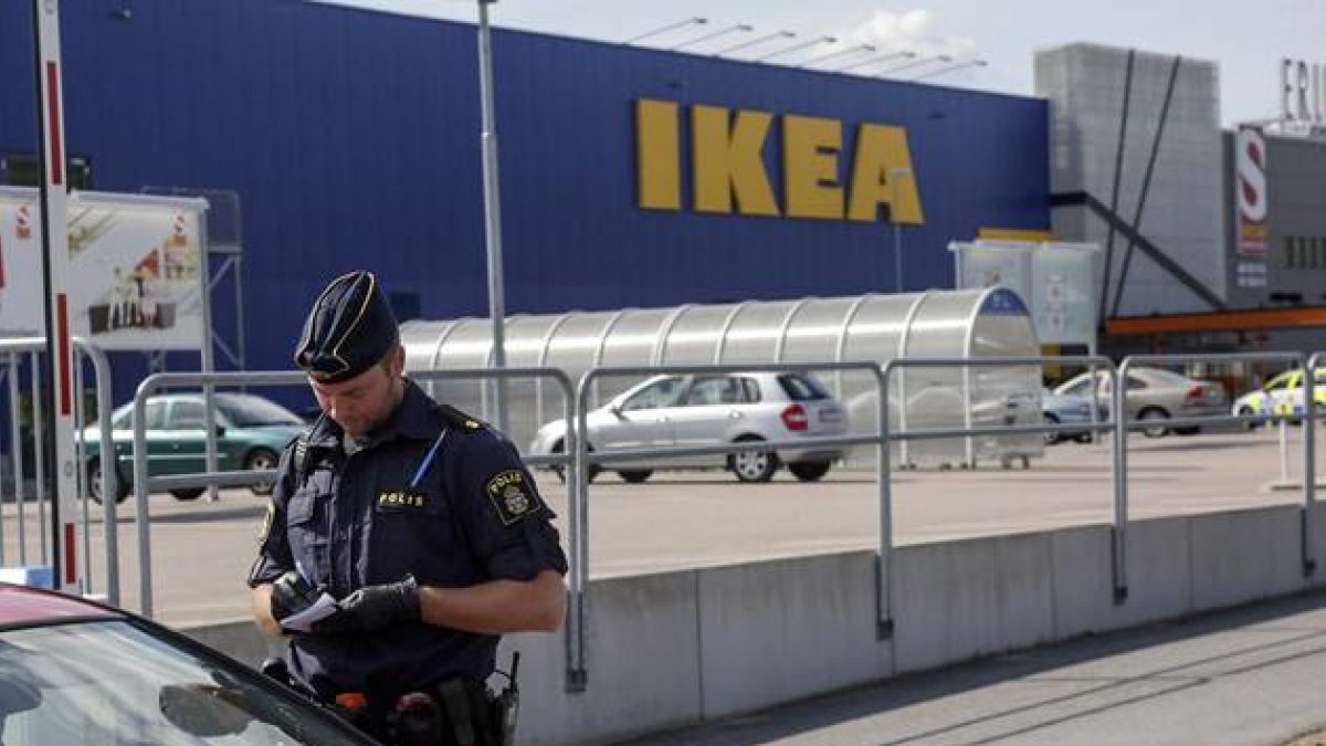 Un agente habla con unos clientes en las afueras del Ikea de Vasteras, en Suecia.-Foto: AP / PETER KRUGER