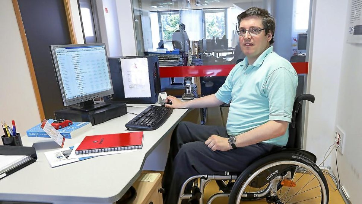 Federico Vallmitjana, a la izquierda, trabajando en la sede de Aspaym en las distintas páginas web de la asociación-J.M. Lostau