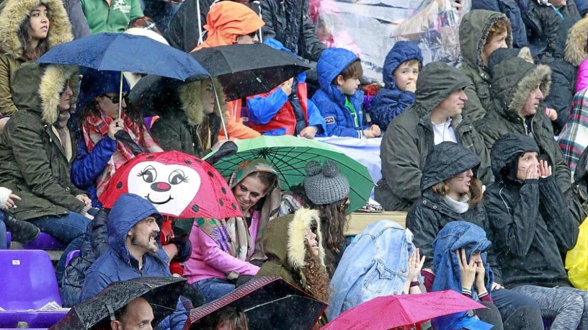 Los aficionados vallisoletanos se protegen de la lluvia durante la final de Copa de Zorrilla.-MIGUEL ÁNGEL SANTOS