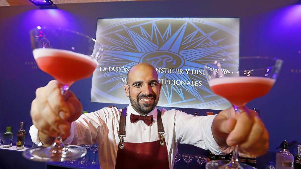 Un barman muestra sus dos cócteles acabados al p úblico.-REPORTAJE FOTOGRÁFICO: J.M. LOSTAU