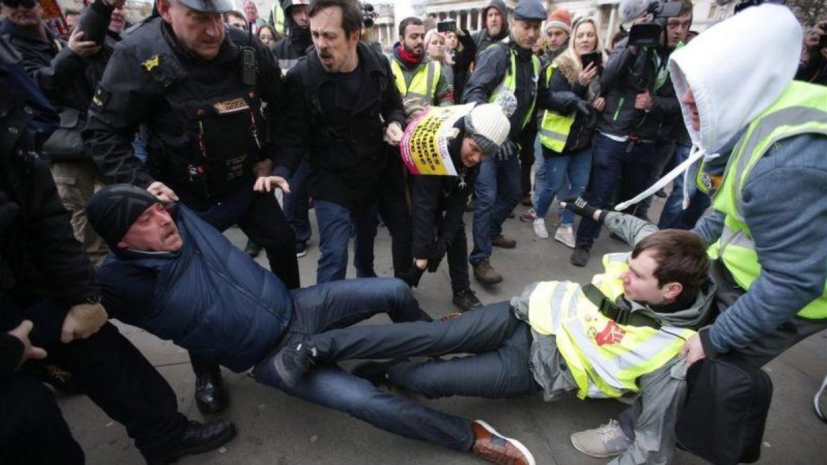 La policía británica y otros manifestantes separan a un partidario y un detractor del brexit en una marcha en Londres.-DANIEL LEAL-OLIVAS (AFP)