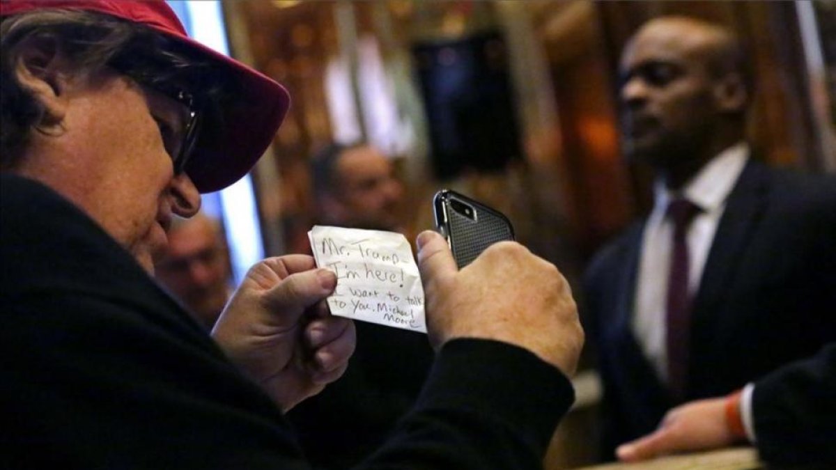 Michael Moore, con la nota que entregó en la Trump Tower de Nueva York.-AFP / YANA PASKOVA
