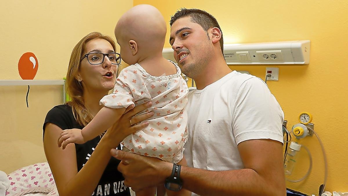 Carlota y Adrián sostienen a su pequeña Cataleya ayer, en la habitación donde lleva cinco meses hospitalizada.-J.M. LOSTAU