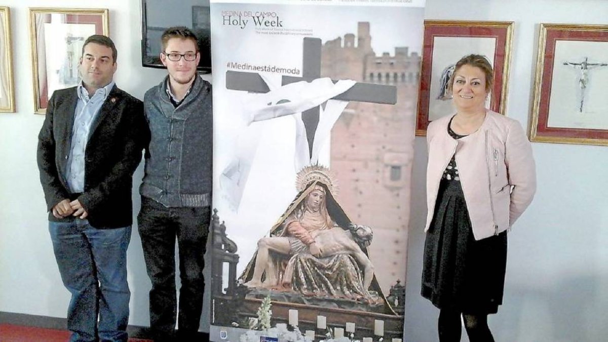 Rubén Mena, José María Magro y Teresa López ayer, junto al cartel promocional de la Semana Santa en inglés-El Mundo