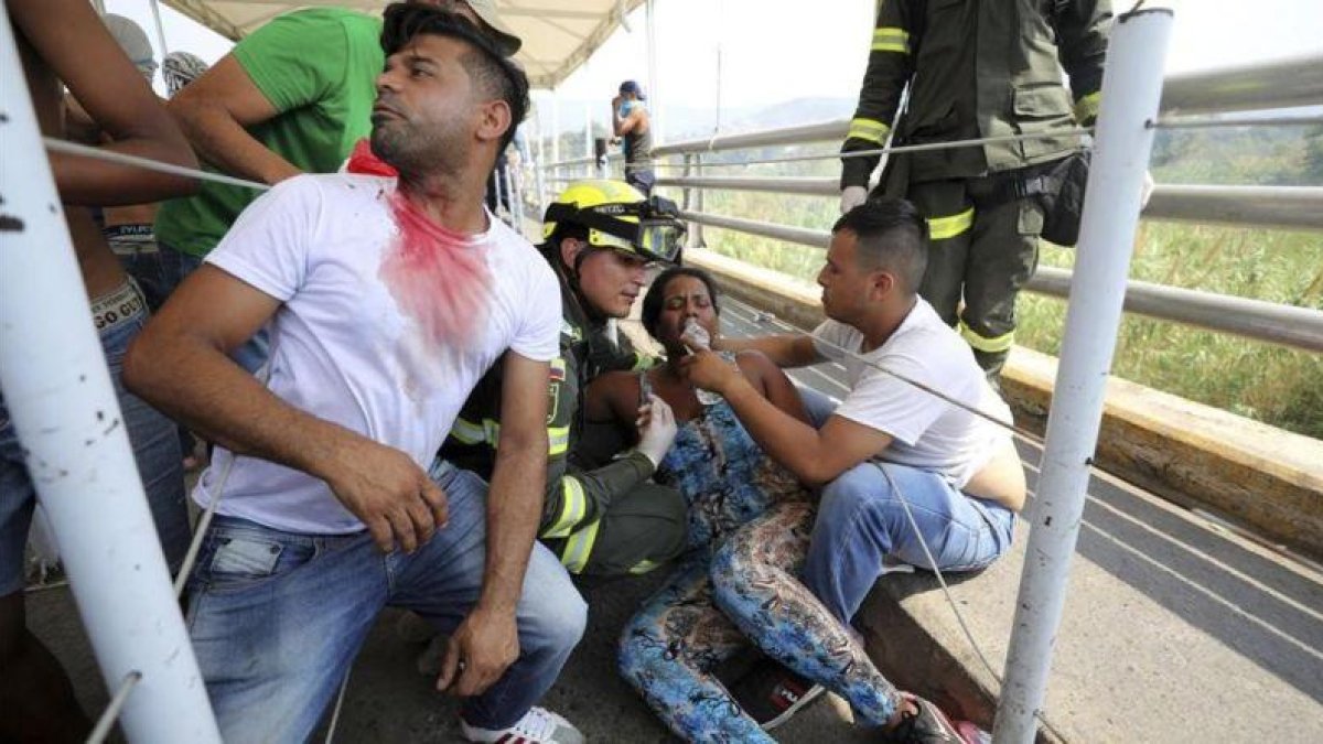 Una mujer afectada por los gases lacrimógenos es atendida por sus compañeros en el puente inetrnacional Simón Bolívar, en Cúcuta (Colombia), el 23 de febrero del 2019.-AP / FERNANDO VERGARA