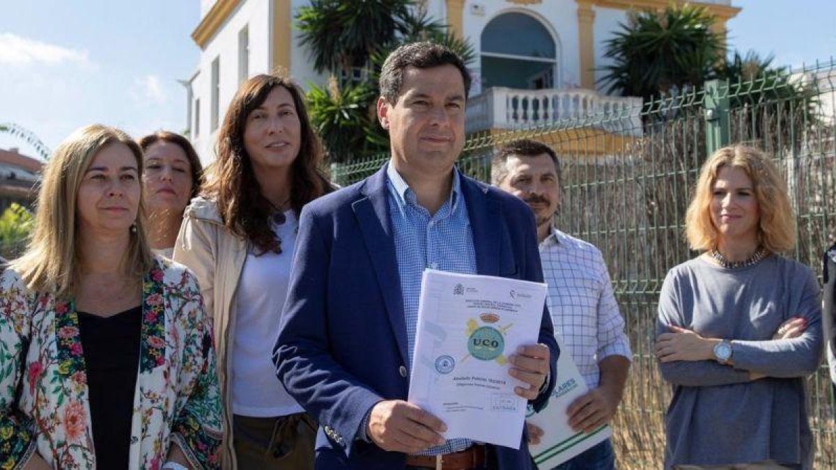 El líder del PP-A, Juan Manuel Moreno Bonilla, con el informe policial de la UCO ante el club de alterne Don Angelo, donde se usaron las tarjetas de crédito de la Faffe.-EFE
