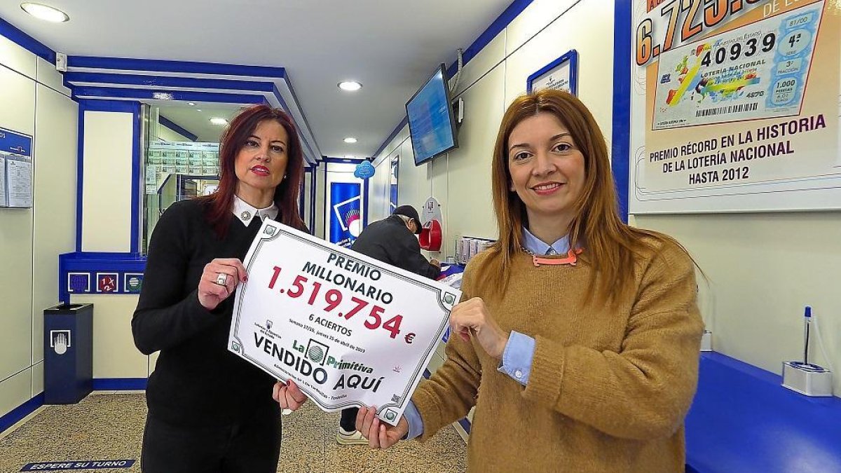 Marta y Patricia muestran un cartel que anuncia el boleto millonario sellado en la Administración de la calle Santa María de Tordesillas.-MIGUEL ÁNGEL SANTOS