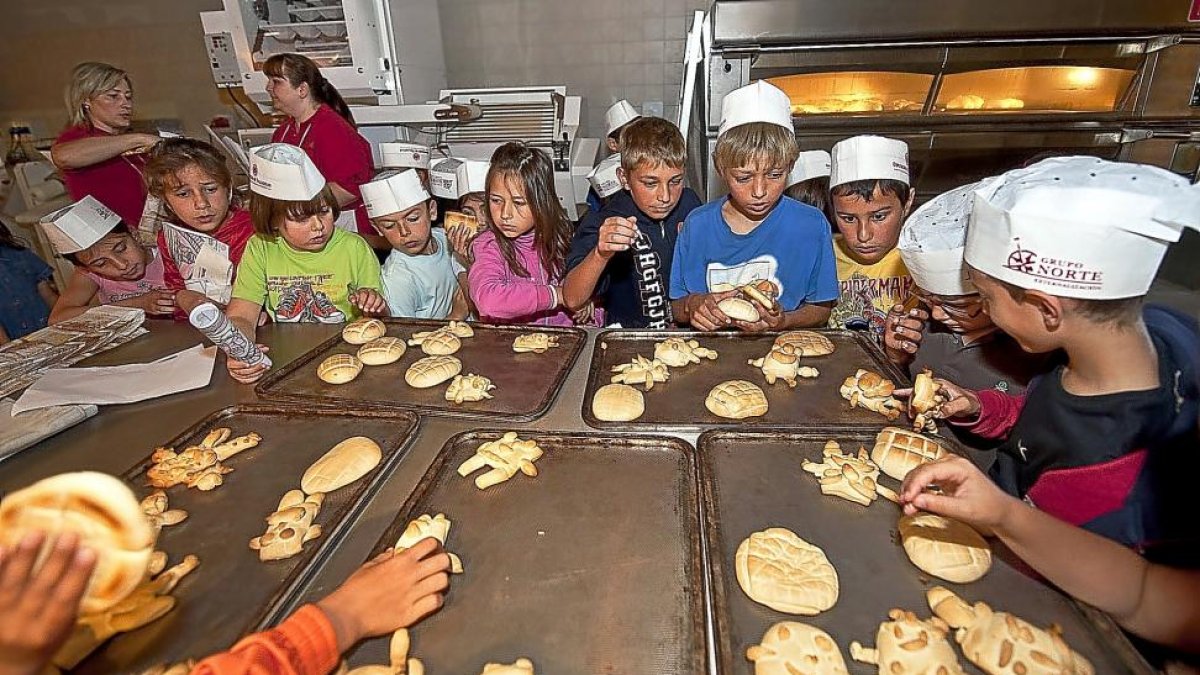 Un grupo de niños participa en un taller de elaboración de pan.-ICAL