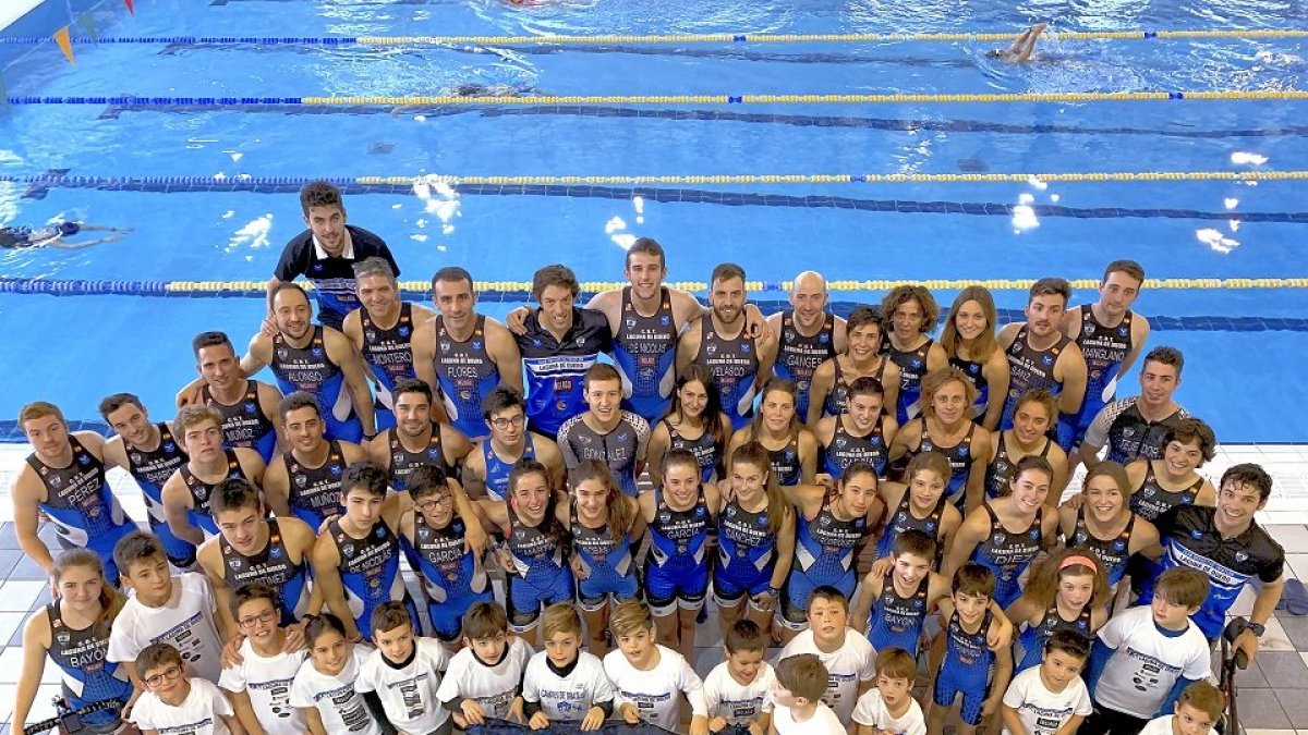 La gran familia del Valladolid Club Triatlón Laguna posa con la piscina al fondo. EL MUNDO