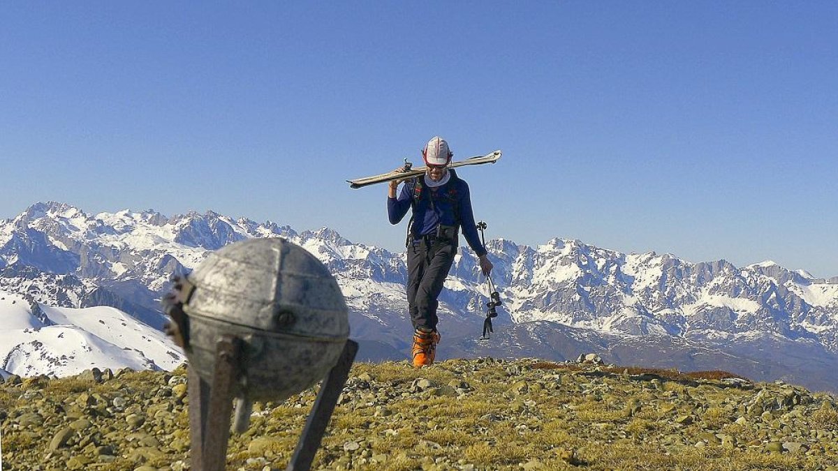 Un montañero alcanza la cumbre del Pico Lezna con los Picos de Europa al fondo.-N.S.