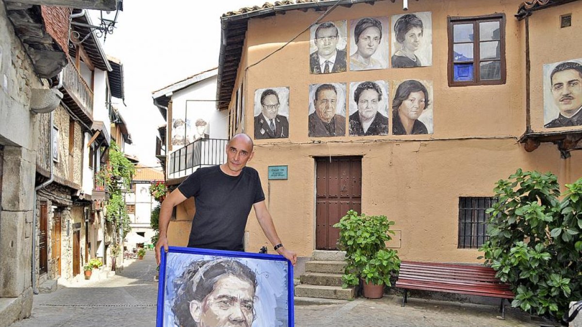 Florencio Maíllo, con uno de los cuadros de gran formato del proyecto artístico Retrata2-388, en una de las calles de Mogarraz donde, desde hace cinco años, cuelgan los retratos de sus antiguos vecinos.-ARGICOMUNICACIÓN