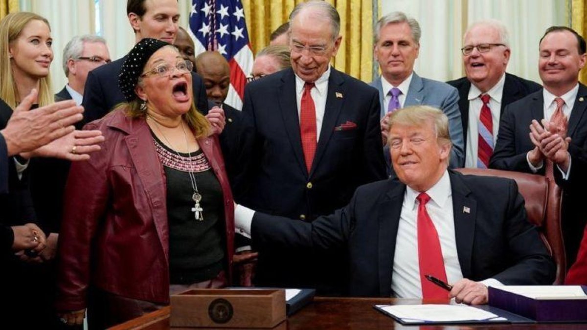 Donald Trump toca a Alveda King, evangelista y sobrina de Luther Martin King, que habló durante la ceremonia de la firma de la Ley Primer Paso, en el Despacho Oval de la Casa Blanca, el 21 de ediciembre del 2018.-REUTERS / JOSHUA ROBERTS