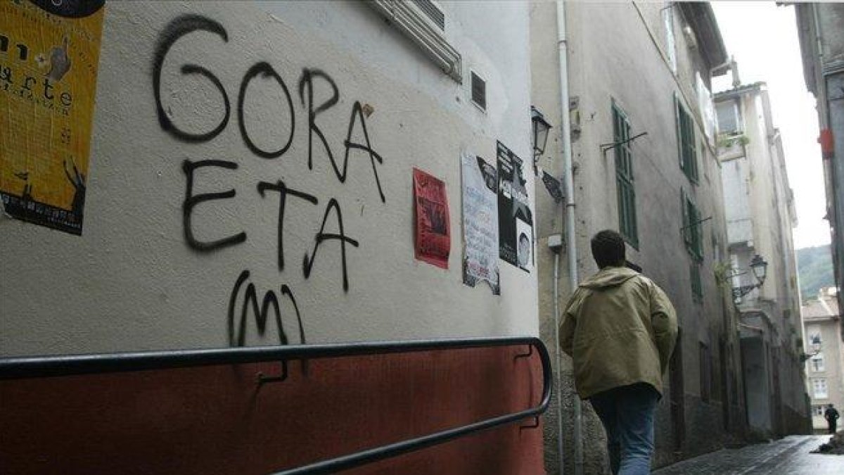 Una persona junto a un graffiti proetarra.-VINCENT WEST