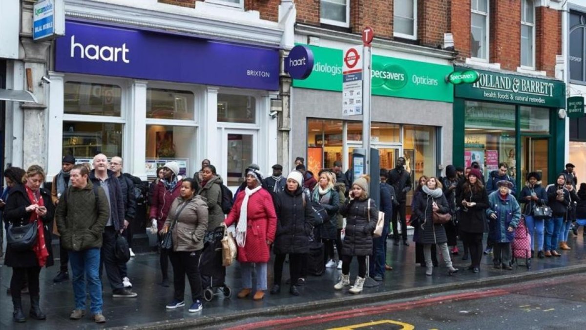 Viajeros hacen cola en la parada para acceder a los autobuses, en Brixton, en el sur de Londres, este lunes.-AFP / NIKLAS HALLE'N