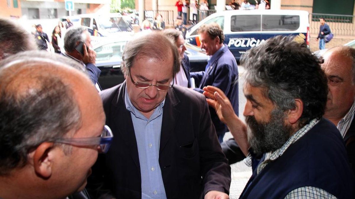 El presidente Herrera asiste a un acto político en León; en la imagen, un ganadero le entrega un papel con peticiones del sector lácteo.-ICAL