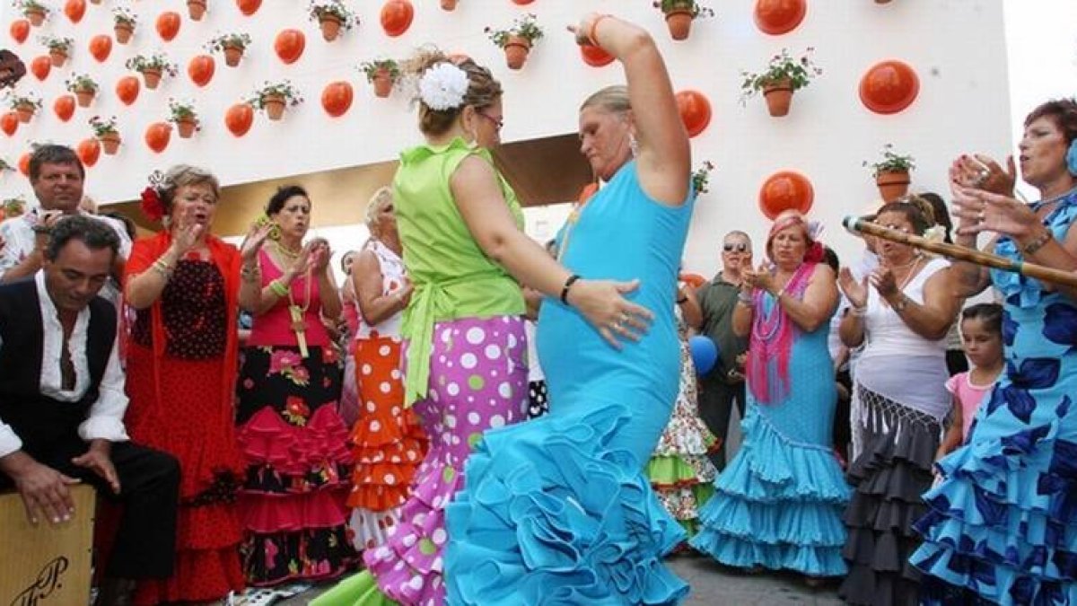 Unas mujeres bailan en un corrillo en el recinto ferial de Málaga, en las fiestas de agosto.-Foto: ARCHIVO / M. POZO