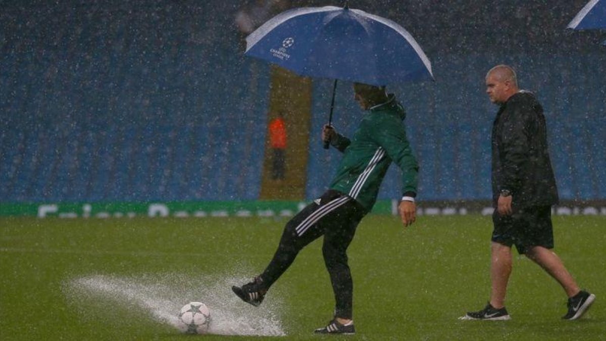 El árbitro, el holandés Kuipers, comprueba las dificultades para que ruede el balón, esta noche en el Etihad.-AP / DAVE THOMPSON